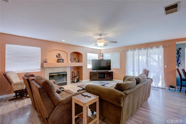 1166 Labrador Ct, Newman, CA 95360 - living room with a tiled fireplace, light wood finished floors, a ceiling fan, and recessed lighting