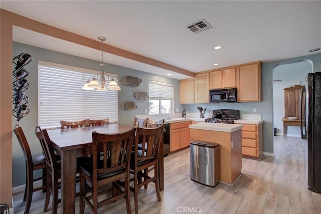 1166 Labrador Ct, Newman, CA 95360 - kitchen with tile countertops, light brown cabinets, a kitchen island, light wood-type flooring, and recessed lighting