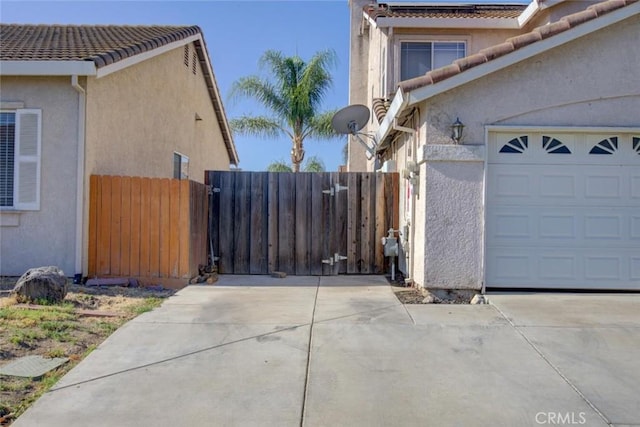 1166 Labrador Ct, Newman, CA 95360 - view of side of home featuring concrete driveway, an attached garage, stucco siding, and a tiled roof