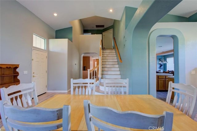 1166 Labrador Ct, Newman, CA 95360 - dining area featuring arched walkways, wood finished floors, stairway, a high ceiling, and recessed lighting