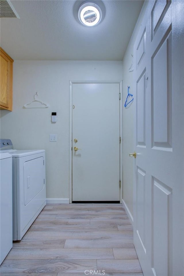 1166 Labrador Ct, Newman, CA 95360 - laundry room with cabinet space, washer and clothes dryer, and light wood-type flooring
