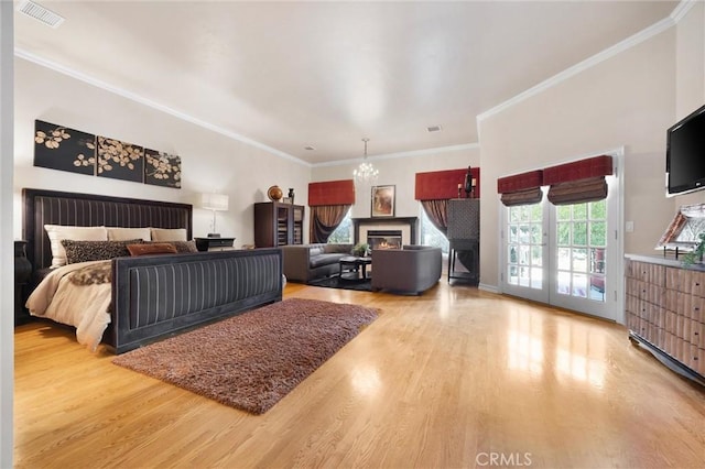 8905 Saint Cloud Ln, Bakersfield, CA 93311 - bedroom with access to exterior, wood finished floors, a chandelier, ornamental molding, and a glass covered fireplace