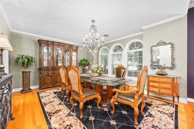 8905 Saint Cloud Ln, Bakersfield, CA 93311 - dining room featuring crown molding, a chandelier, and light wood-style flooring
