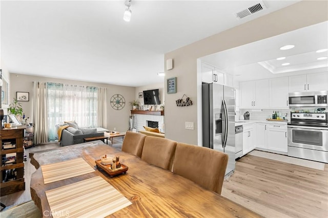 1330 W Apricot Ave, Lompoc, CA 93436 - dining space featuring light wood-style flooring, a brick fireplace, and recessed lighting