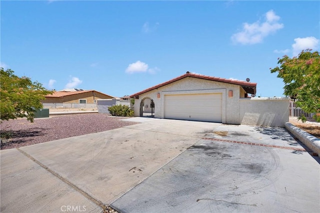 26453 Buccaneer Ln, Helendale, CA 92342 - mediterranean / spanish house with stucco siding, a garage, and driveway