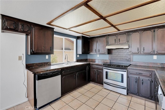 26453 Buccaneer Ln, Helendale, CA 92342 - kitchen with dark countertops, appliances with stainless steel finishes, dark brown cabinets, light tile patterned flooring, and under cabinet range hood