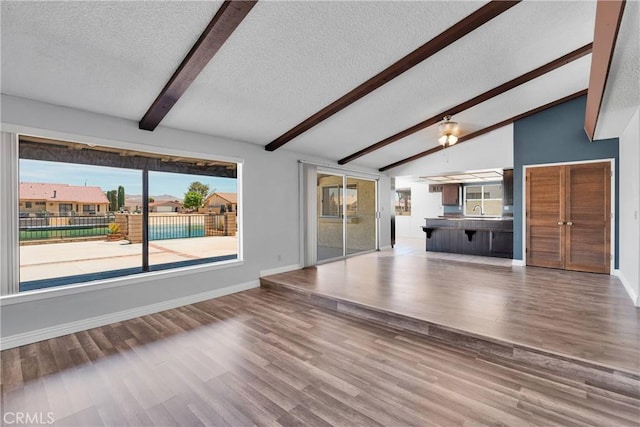 26453 Buccaneer Ln, Helendale, CA 92342 - unfurnished living room featuring a textured ceiling, wood finished floors, and healthy amount of natural light
