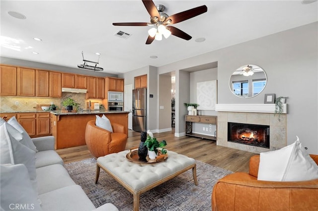 7 Sachem Way, Ladera Ranch, CA 92694 - living area featuring a ceiling fan, light wood-style floors, a tile fireplace, and recessed lighting