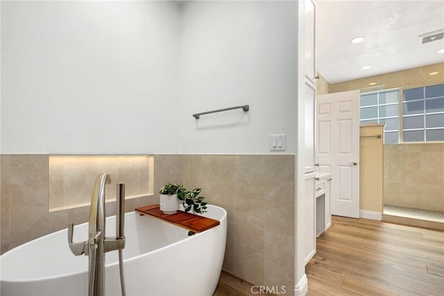 7 Sachem Way, Ladera Ranch, CA 92694 - bathroom featuring tile walls, wood finished floors, a freestanding bath, recessed lighting, and walk in shower
