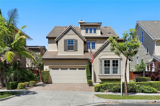 7 Sachem Way, Ladera Ranch, CA 92694 - traditional home featuring decorative driveway, stucco siding, a garage, a tile roof, and a chimney