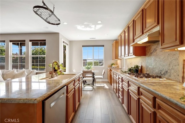 7 Sachem Way, Ladera Ranch, CA 92694 - kitchen with dishwasher, brown cabinetry, decorative backsplash, light stone counters, and wood finished floors