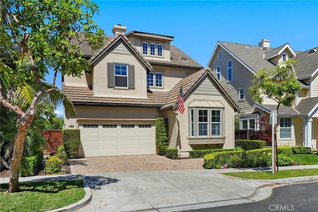 7 Sachem Way, Ladera Ranch, CA 92694 - view of front of house featuring decorative driveway, stucco siding, a garage, a chimney, and a tiled roof