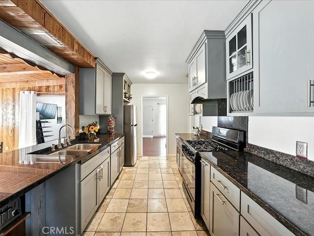 20319 Vanowen St, Winnetka, CA 91306 - kitchen with gas stove, gray cabinetry, dark stone counters, and glass insert cabinets
