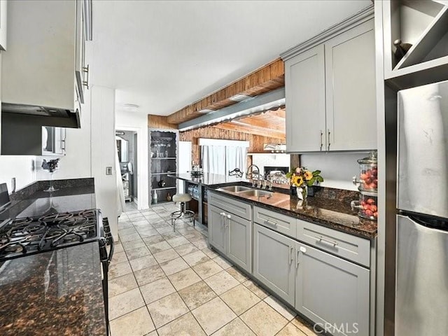 20319 Vanowen St, Winnetka, CA 91306 - kitchen with gray cabinetry, black gas stove, freestanding refrigerator, and dark stone counters