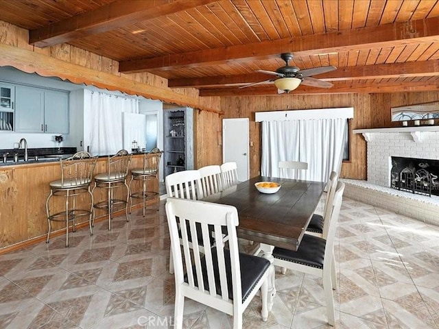 20319 Vanowen St, Winnetka, CA 91306 - dining space featuring wooden walls, a wooden ceiling with exposed beams, a ceiling fan, and a brick fireplace