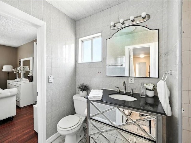 20319 Vanowen St, Winnetka, CA 91306 - bathroom featuring tile walls, vanity, wood finished floors, and a textured ceiling