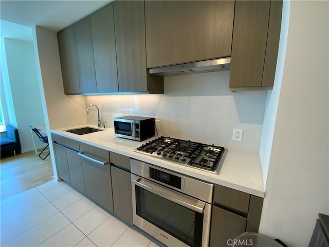 889 Francisco St Unit 1105, Los Angeles, CA 90017 - kitchen featuring stainless steel appliances, light countertops, under cabinet range hood, and gray cabinetry