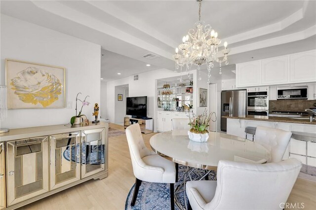 5224 Zelzah Ave Unit 208, Encino, CA 91316 - dining room with a chandelier, light wood-style floors, recessed lighting, and a tray ceiling