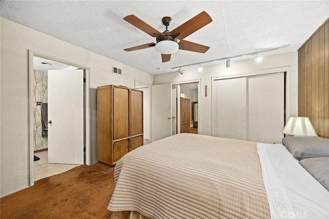 2912 Fragancia Ave, Hacienda Heights, CA 91745 - bedroom featuring track lighting, light colored carpet, multiple closets, a textured ceiling, and ceiling fan