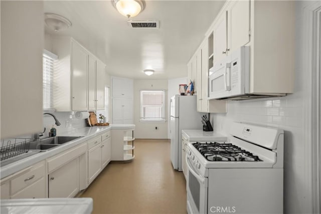 33 Miner St, Bakersfield, CA 93305 - kitchen featuring white appliances, white cabinetry, backsplash, and light countertops