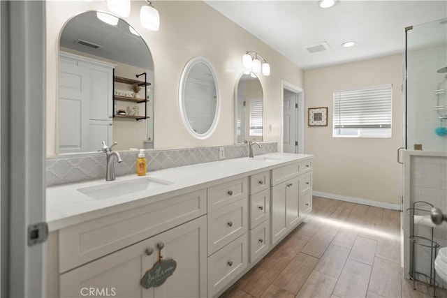 33 Miner St, Bakersfield, CA 93305 - bathroom with double vanity, wood finished floors, backsplash, recessed lighting, and a shower with shower door