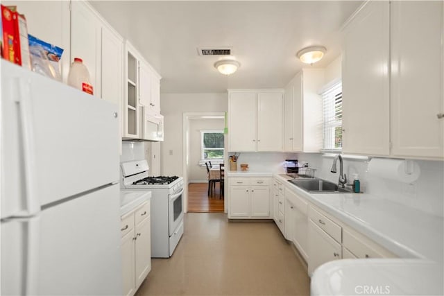 33 Miner St, Bakersfield, CA 93305 - kitchen with white appliances, white cabinetry, light countertops, light flooring, and glass insert cabinets