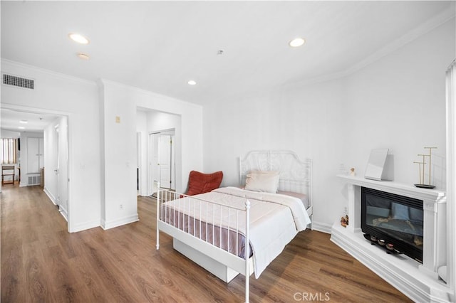565 E San Jose Ave Unit 204, Burbank, CA 91501 - bedroom featuring ornamental molding, wood finished floors, recessed lighting, and a glass covered fireplace