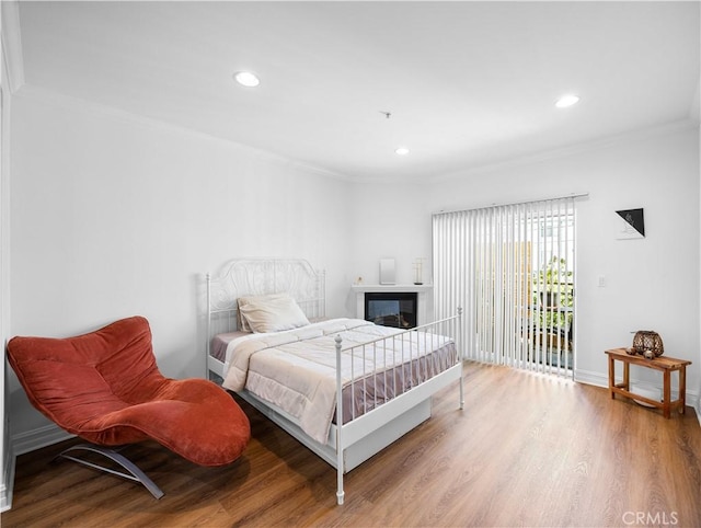 565 E San Jose Ave Unit 204, Burbank, CA 91501 - bedroom with ornamental molding, wood finished floors, access to exterior, recessed lighting, and a glass covered fireplace