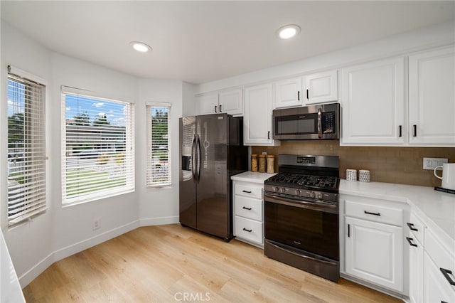 3705 Cypress Ln, Yorba Linda, CA 92886 - kitchen with appliances with stainless steel finishes, light wood finished floors, white cabinets, decorative backsplash, and recessed lighting
