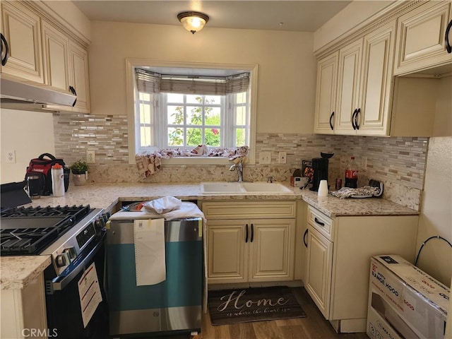 17077 Los Modelos St, Fountain Valley, CA 92708 - kitchen featuring stainless steel gas range oven, cream cabinetry, decorative backsplash, dark wood finished floors, and light stone counters