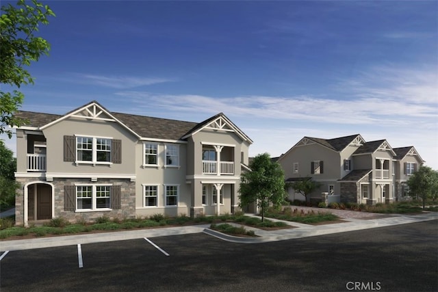 3909 E Coronado Privado, Ontario, CA 91761 - view of front of house with a balcony, stone siding, uncovered parking, and stucco siding