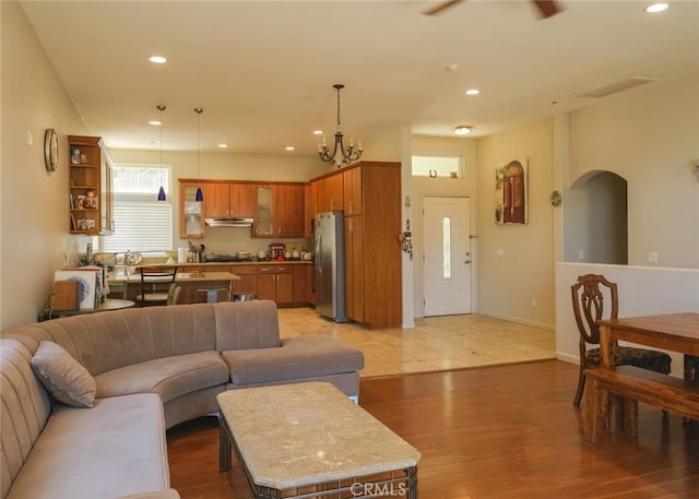 1324 Pinetree Dr, Frazier Park, CA 93225 - living room featuring recessed lighting, light wood finished floors, ceiling fan, a chandelier, and arched walkways