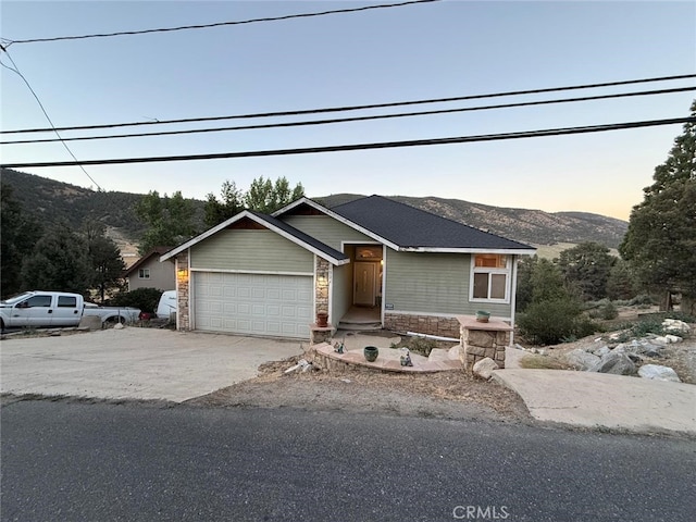 1324 Pinetree Dr, Frazier Park, CA 93225 - view of front of property with concrete driveway, a mountain view, a garage, and stone siding