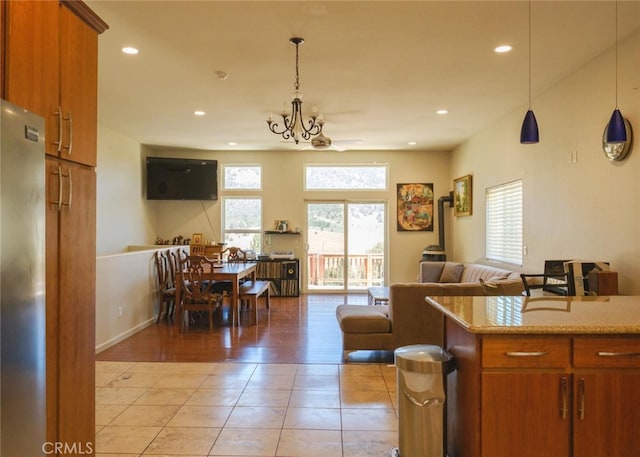 1324 Pinetree Dr, Frazier Park, CA 93225 - kitchen with open floor plan, brown cabinets, light tile patterned floors, hanging light fixtures, and freestanding refrigerator