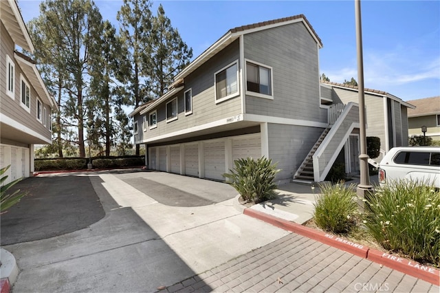 45 Bramble Ln Unit 109, Aliso Viejo, CA 92656 - view of side of property with stairs, driveway, and a garage