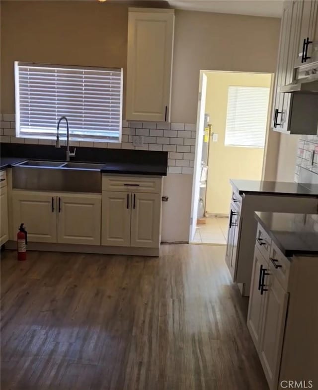 625 Xenia Ave, Beaumont, CA 92223 - kitchen with dark countertops, tasteful backsplash, wood finished floors, and white cabinetry