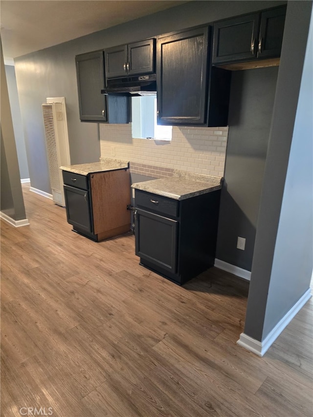 625 Xenia Ave, Beaumont, CA 92223 - kitchen with backsplash, wood finished floors, a heating unit, light countertops, and under cabinet range hood
