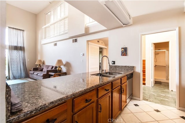 5440 Lindley Ave Unit 310, Encino, CA 91316 - kitchen with brown cabinetry, dark stone counters, dishwasher, and light tile patterned flooring