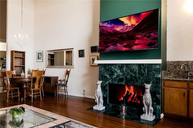 5440 Lindley Ave Unit 310, Encino, CA 91316 - living room featuring wood finished floors, a chandelier, a fireplace, and a towering ceiling