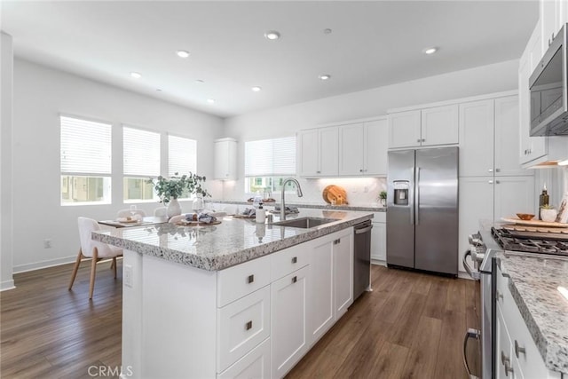 27554 Sparrow Ct, Valencia, CA 91381 - kitchen with appliances with stainless steel finishes, dark wood-style floors, white cabinetry, light stone counters, and recessed lighting