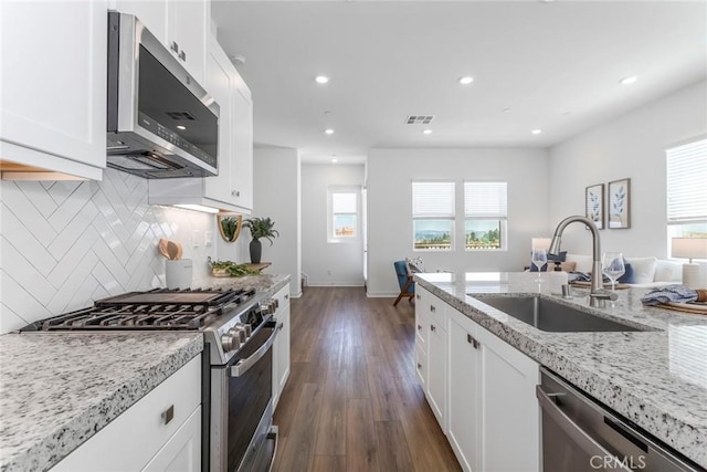 27554 Sparrow Ct, Valencia, CA 91381 - kitchen with appliances with stainless steel finishes, healthy amount of natural light, tasteful backsplash, light stone countertops, and recessed lighting