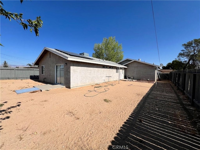7512 Xavier Ave, California City, CA 93505 - rear view of property featuring a fenced backyard, solar panels, stucco siding, and a patio