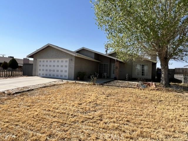 7512 Xavier Ave, California City, CA 93505 - ranch-style house with a garage, driveway, and stucco siding