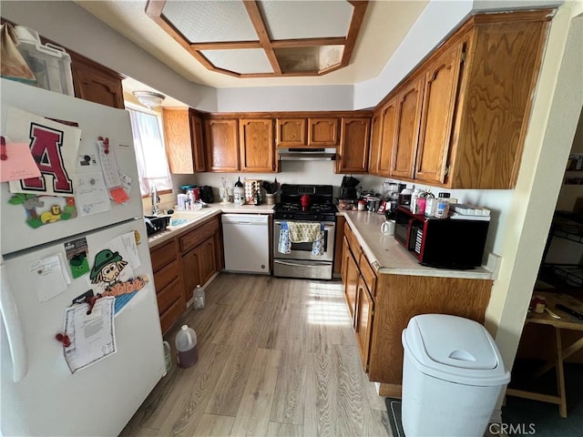 7512 Xavier Ave, California City, CA 93505 - kitchen with white appliances, brown cabinets, light wood-style floors, and light countertops