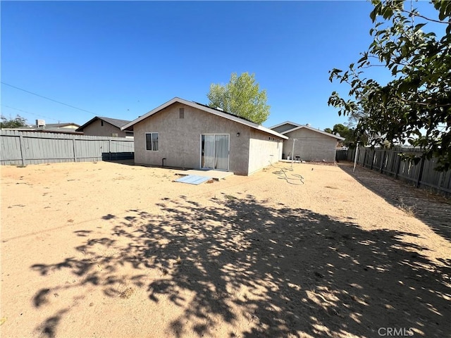 7512 Xavier Ave, California City, CA 93505 - back of house with stucco siding and a fenced backyard