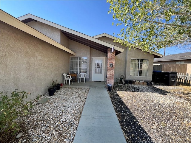 7512 Xavier Ave, California City, CA 93505 - doorway to property with stucco siding, a patio, and brick siding
