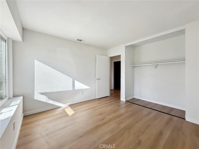1472 N San Antonio Ave, Upland, CA 91786 - unfurnished bedroom with wood finished floors, multiple windows, and a closet
