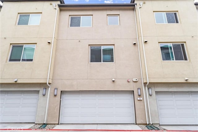 14053 Spurlock Ln Unit 3, Gardena, CA 90247 - rear view of property featuring a garage, stucco siding, and driveway