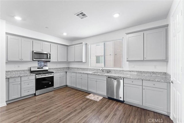 14053 Spurlock Ln Unit 3, Gardena, CA 90247 - kitchen with appliances with stainless steel finishes, wood finished floors, recessed lighting, light stone counters, and gray cabinetry