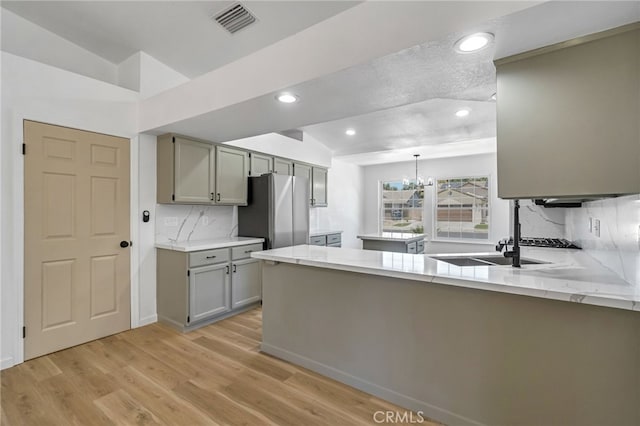 1534 Princeton Ave, Madera, CA 93637 - kitchen featuring gray cabinets, a peninsula, backsplash, light wood-type flooring, and recessed lighting